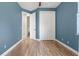 Bright bedroom with blue walls, wood-look floors, and closet space at 8058 Santa Cruz Dr, Port Charlotte, FL 33981
