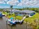 Aerial view of a single-story home featuring a screened-in pool, a dock and backyard at 8058 Santa Cruz Dr, Port Charlotte, FL 33981