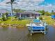 Back view of a single-story home featuring a screened-in pool, a boat and a private dock at 8058 Santa Cruz Dr, Port Charlotte, FL 33981