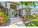 Inviting front entrance with decorative landscaping, stone accents, and a covered porch at 8058 Santa Cruz Dr, Port Charlotte, FL 33981