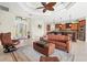 Open-concept living room flows into a kitchen with brown cabinets and stainless appliances at 8058 Santa Cruz Dr, Port Charlotte, FL 33981