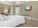 Bright bedroom with a TV, ceiling fan, and wood floors with decorative clock at 8058 Santa Cruz Dr, Port Charlotte, FL 33981