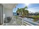 Balcony view overlooking palm trees, the canal, and boats; outdoor chairs for enjoying the waterfront at 8222 Harborside Cir, Englewood, FL 34224