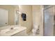 Bright bathroom featuring a vanity with a sink, toilet, and a walk-in shower with glass door at 8222 Harborside Cir, Englewood, FL 34224