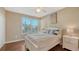Well-lit bedroom featuring a queen bed, hardwood floors, and ample natural light from two windows at 8222 Harborside Cir, Englewood, FL 34224