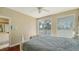 Bright bedroom featuring a queen bed, balcony access, hardwood floors, and comfortable furnishings at 8222 Harborside Cir, Englewood, FL 34224