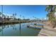Picturesque dock with serene canal views, palm trees, and clear blue skies, ideal for boat enthusiasts at 8222 Harborside Cir, Englewood, FL 34224