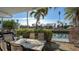 Inviting waterfront patio with outdoor seating, grill, and views of the canal and nearby boats at 8222 Harborside Cir, Englewood, FL 34224