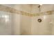 Close-up of a tiled shower with decorative accent and a standard shower head and handle at 8222 Harborside Cir, Englewood, FL 34224
