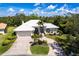 Beautiful property with a well-manicured lawn, palm trees and a spacious driveway, creating inviting curb appeal at 832 Carnoustie Dr, Venice, FL 34293
