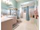 Pastel pink bathroom featuring a large mirror, dual sinks, and a bathtub at 832 Carnoustie Dr, Venice, FL 34293