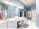 Light and airy blue bathroom with double sinks and a vanity area at 832 Carnoustie Dr, Venice, FL 34293