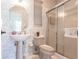 Bathroom with a pedestal sink, shower, and decorative wallpaper creates a calming retreat at 832 Carnoustie Dr, Venice, FL 34293