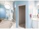 Light blue bathroom featuring a bathtub and walk-in shower with light tile floors at 832 Carnoustie Dr, Venice, FL 34293
