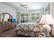 Bedroom with wood floors, neutral walls, a ceiling fan, and a dresser with access to the lanai at 832 Carnoustie Dr, Venice, FL 34293