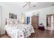 Bright bedroom featuring decorative bedding, wood floors, a ceiling fan, and plenty of sunlight at 832 Carnoustie Dr, Venice, FL 34293