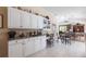 Breakfast nook with granite countertops, white cabinets, and views into the living area at 832 Carnoustie Dr, Venice, FL 34293