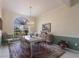 Dining room features a decorative chandelier, arched window with shade, and natural lighting at 832 Carnoustie Dr, Venice, FL 34293
