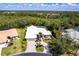 Beautiful single-story home featuring a well-manicured lawn, mature trees, and a circular driveway at 832 Carnoustie Dr, Venice, FL 34293