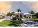 Charming home with palm trees, lush landscaping and a driveway leading to an attached two-car garage at 832 Carnoustie Dr, Venice, FL 34293