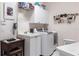 Laundry room with a utility sink, front loading washer and dryer, and storage at 832 Carnoustie Dr, Venice, FL 34293