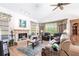 Bright living room featuring a stone fireplace, wood floors, and neutral décor, with plenty of natural light at 832 Carnoustie Dr, Venice, FL 34293