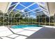 Beautiful screened-in pool with adjacent hot tub, surrounded by lush greenery for ultimate privacy and relaxation at 832 Carnoustie Dr, Venice, FL 34293
