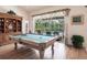 Recreation room featuring a pool table, wood floors, and view of screened lanai with in ground pool at 832 Carnoustie Dr, Venice, FL 34293