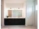 Bright bathroom features a double vanity with dark cabinets, a large mirror, and modern lighting at 8405 Golden Beach Ct, Parrish, FL 34219