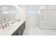 A modern bathroom with dual sinks, a large mirror, and a glass-enclosed shower at 8405 Golden Beach Ct, Parrish, FL 34219
