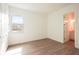Sunlit bedroom has hardwood floors, a window, and a door to an ensuite bathroom at 8405 Golden Beach Ct, Parrish, FL 34219