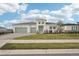 Charming single-story home features a manicured lawn, three-car garage, and bright white exterior at 8405 Golden Beach Ct, Parrish, FL 34219