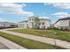 Street view of a modern home with a three-car garage, landscaped lawn, and paver driveway at 8405 Golden Beach Ct, Parrish, FL 34219