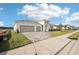 New construction showcasing a three-car garage, paver driveway, and lush green lawn in a modern design at 8405 Golden Beach Ct, Parrish, FL 34219