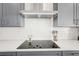 Modern kitchen features gray cabinets, a white subway tile backsplash, and stainless steel appliances at 8405 Golden Beach Ct, Parrish, FL 34219