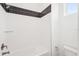 Clean shower with white tiled walls, a black accent stripe, and sleek fixtures at 8405 Golden Beach Ct, Parrish, FL 34219