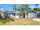 Charming single-story home with blue exterior, stone accents, well-manicured lawn, and an attached white one car garage at 8731 Peggy Ave, Sarasota, FL 34231
