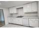 Kitchen with white cabinets, a double sink, dishwasher and tile flooring at 8731 Peggy Ave, Sarasota, FL 34231