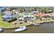 Waterfront property featuring a backyard pool, tiki hut, private dock, and boat on the canal at 10616 Ayear Rd, Port Charlotte, FL 33981
