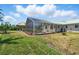 Wide backyard showcasing the screened pool enclosure and a Tiki hut with a grill at 10616 Ayear Rd, Port Charlotte, FL 33981