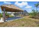 Wide backyard showcasing the screened pool enclosure and a Tiki hut with a grill at 10616 Ayear Rd, Port Charlotte, FL 33981