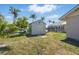 Backyard with a shed and screened lanai, surrounded by green grass and landscaping at 10616 Ayear Rd, Port Charlotte, FL 33981