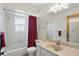 Cozy bathroom featuring a tiled shower/tub, vanity with sink, and a window for natural light at 10616 Ayear Rd, Port Charlotte, FL 33981