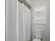 Bright bathroom with a shower featuring a white shower curtain and shuttered window at 10616 Ayear Rd, Port Charlotte, FL 33981