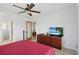 Bright bedroom featuring a ceiling fan, tiled floors, and ensuite bathroom access at 10616 Ayear Rd, Port Charlotte, FL 33981