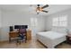 Bedroom featuring tiled floors, a ceiling fan, a desk setup, and a comfortable bed at 10616 Ayear Rd, Port Charlotte, FL 33981