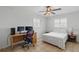 Bedroom featuring tiled floors, a ceiling fan, a desk setup, and a comfortable bed at 10616 Ayear Rd, Port Charlotte, FL 33981