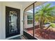 Close-up of a decorative front door with an elegant glass panel and landscaped yard views at 10616 Ayear Rd, Port Charlotte, FL 33981
