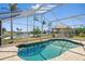 Outdoor pool area featuring a screen enclosure, tiki hut, and picturesque water views at 10616 Ayear Rd, Port Charlotte, FL 33981