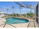 Beautiful in-ground pool surrounded by a screened enclosure and lush landscaping at 10616 Ayear Rd, Port Charlotte, FL 33981